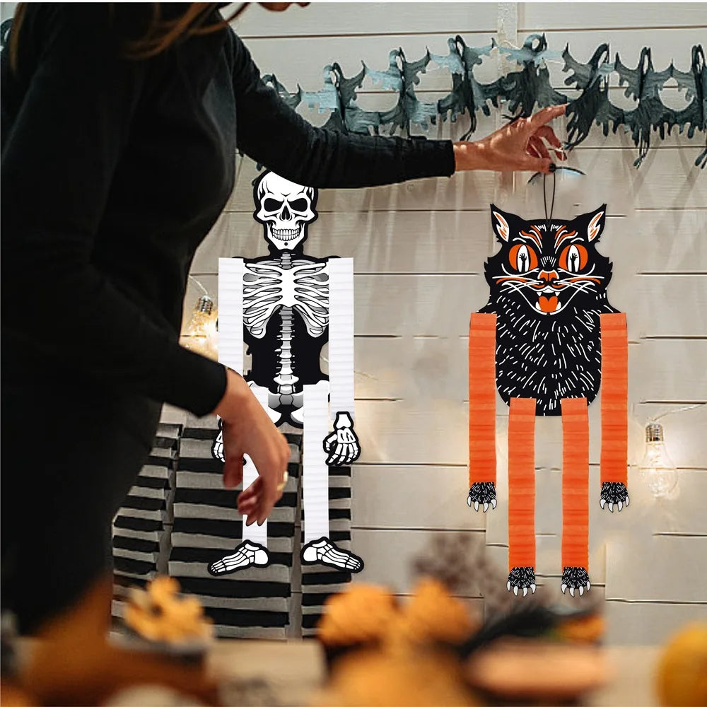 A set of Halloween hanging ornaments featuring ghosts, skeletons, and pumpkins displayed against a white wooden background.