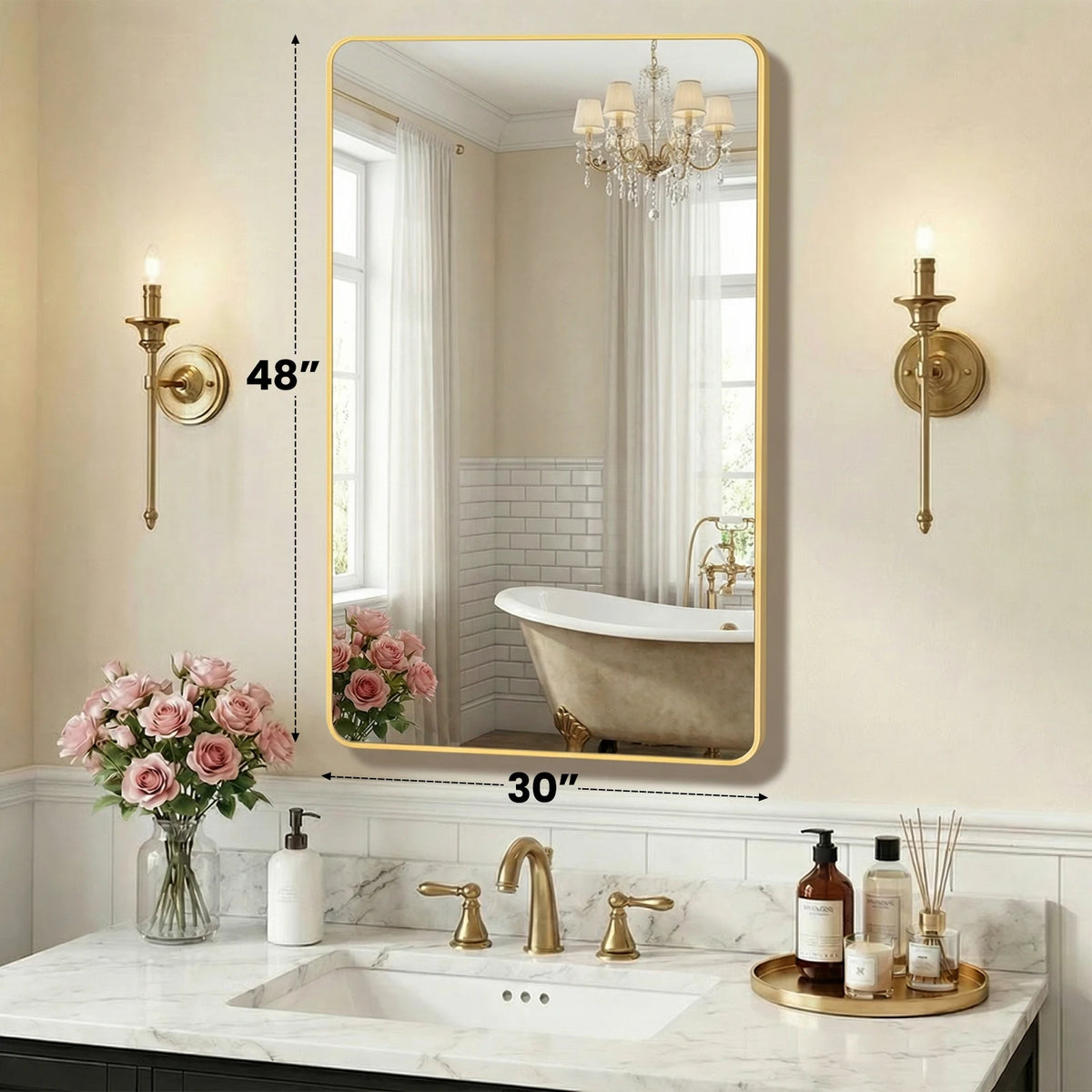 A modern wall mirror with a gold metal frame reflecting a bathroom vanity and bathtub.