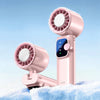 A pink handheld fan with a cooling grille is shown resting on a surface covered in snow.