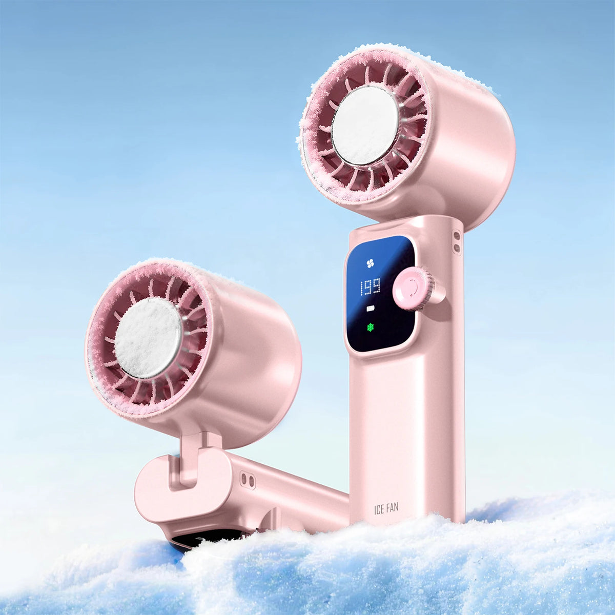 A pink handheld fan with a cooling grille is shown resting on a surface covered in snow.