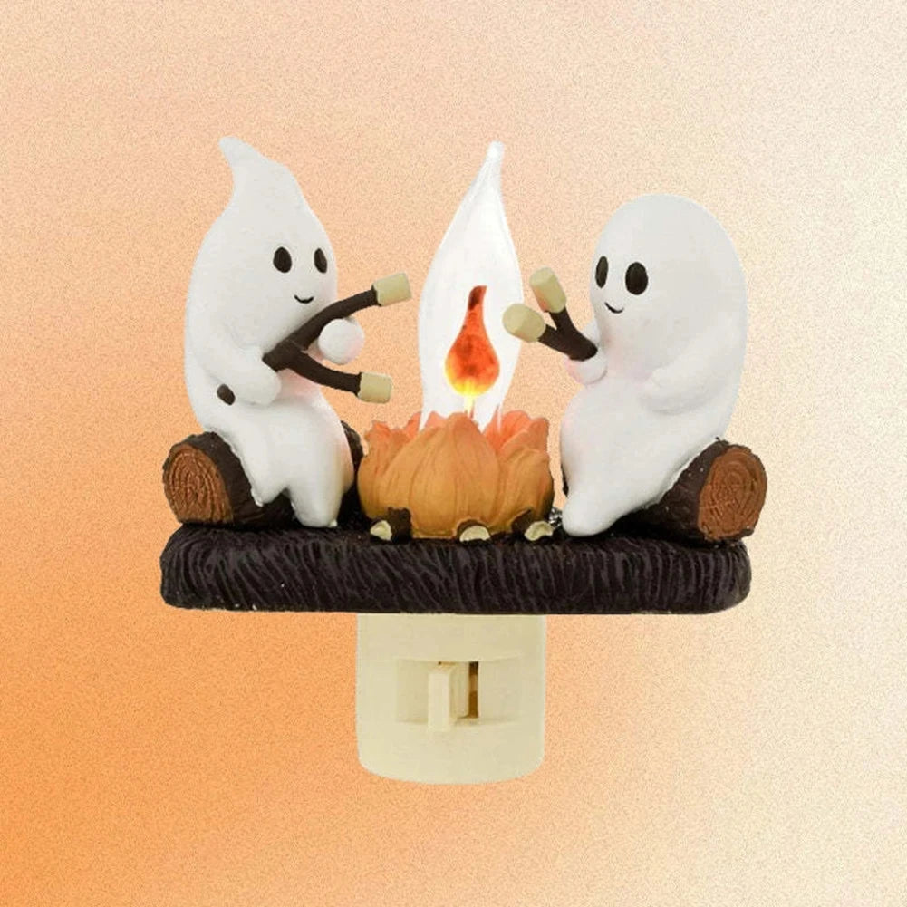 A ceramic night light depicting two ghost figures holding a flickering orange flame.
