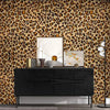 A dark dresser is displayed against a leopard print wall with a large mirror and decorative objects.