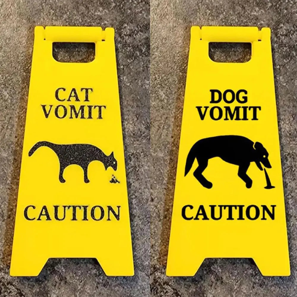 Yellow yard signs with black silhouettes warning against cat and dog vomit.
