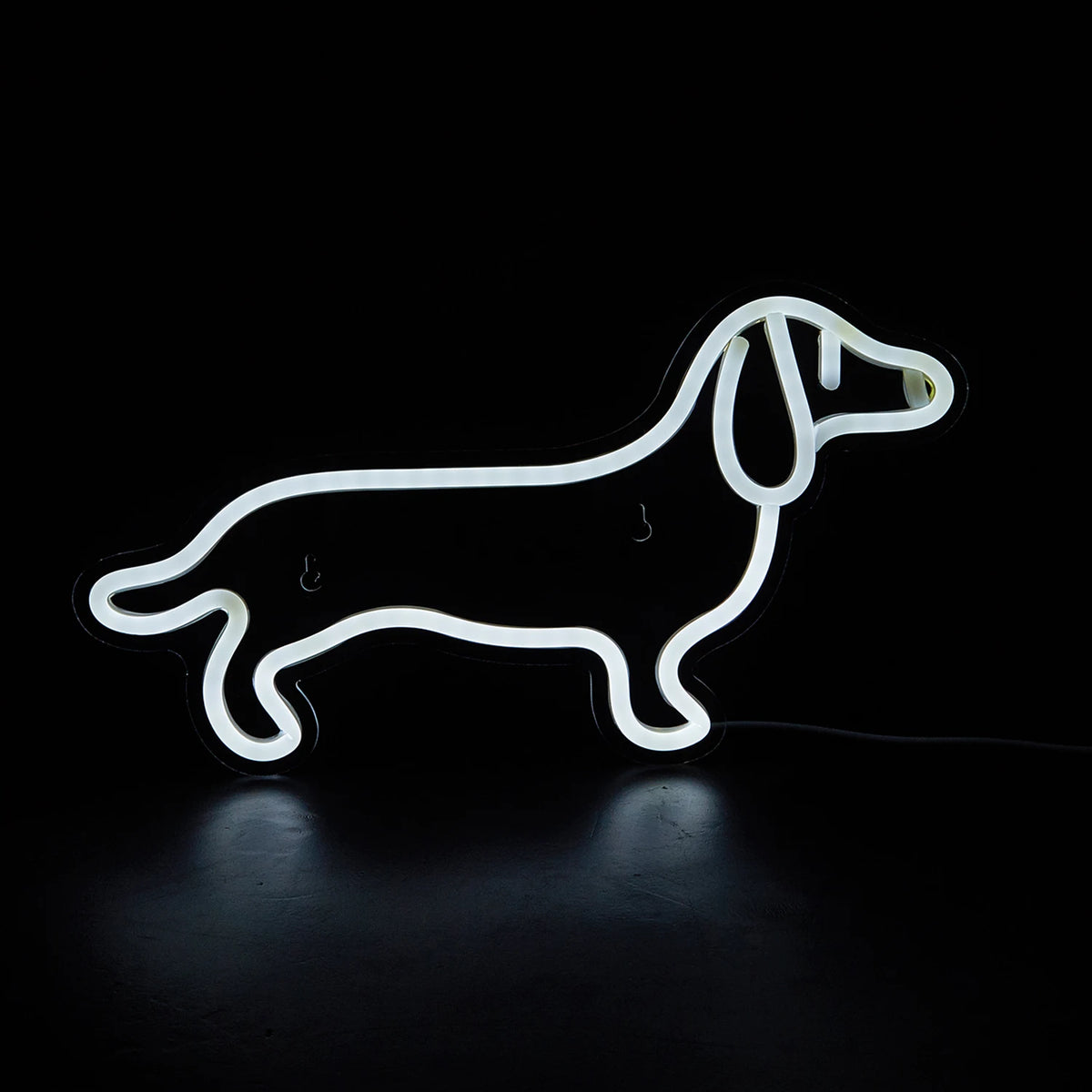 A white neon sign shaped like a dog silhouette glowing against a black background.