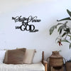 A minimalist metal wall sign featuring the text Be Still and Know that I am God with a palm of olive branch.
