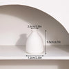 A white ceramic vase is displayed on a shelf with dimension markings.