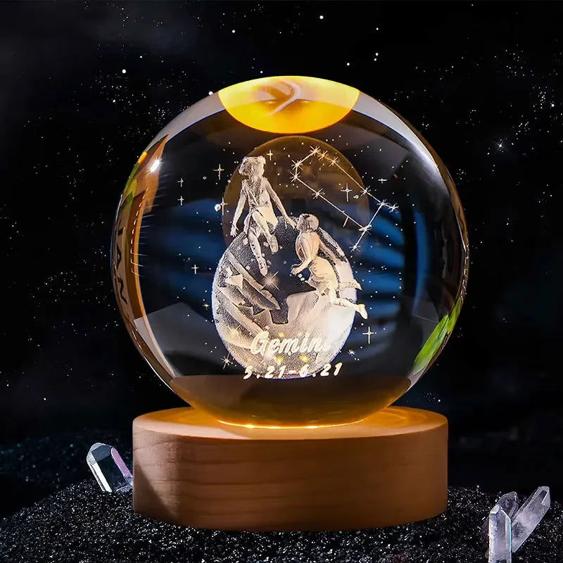 A clear crystal ball decoration with a celestial design and the Gemini zodiac sign engraved on its surface.