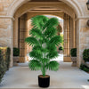 A large artificial palm tree with vibrant green fronds standing in a potted plant within an arched stone walkway.