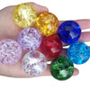A hand holds several colorful crystal ice crack balls in various shades including yellow, purple, blue, red, and green.