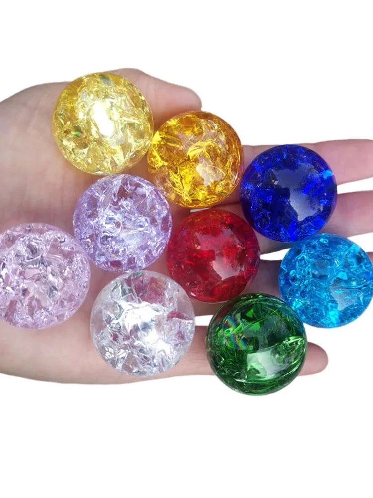 A hand holds several colorful crystal ice crack balls in various shades including yellow, purple, blue, red, and green.