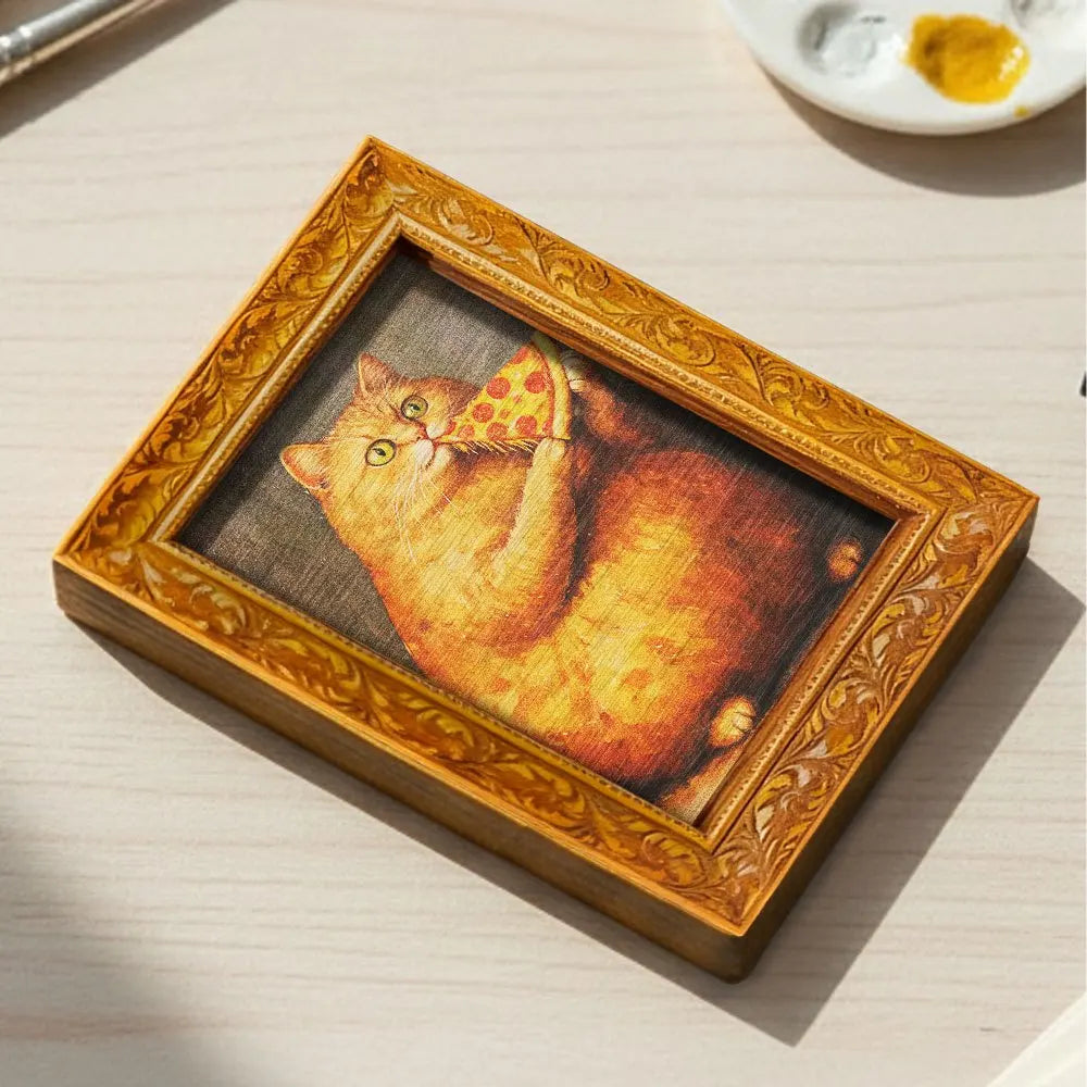 A wooden framed picture of an orange cat looking at the viewer.