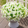 A dense arrangement of white morning glory flowers and green eucalyptus stems in a gray pot.