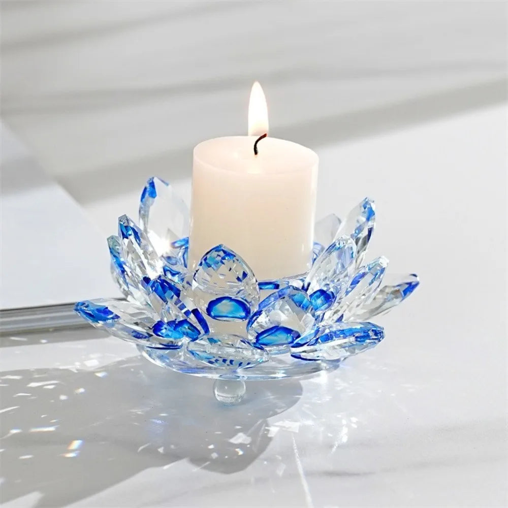 A clear crystal lotus candle holder with a white tealight candle on a white marble surface.