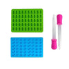 A set of green and blue silicone candy molds with pink droppers for DIY chocolates and jellies