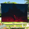 A tapestry featuring dark silhouettes of mountains and a red landscape against a night sky.