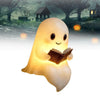 A glowing ghost figurine with a smiling face is holding an open book in a spooky outdoor setting.