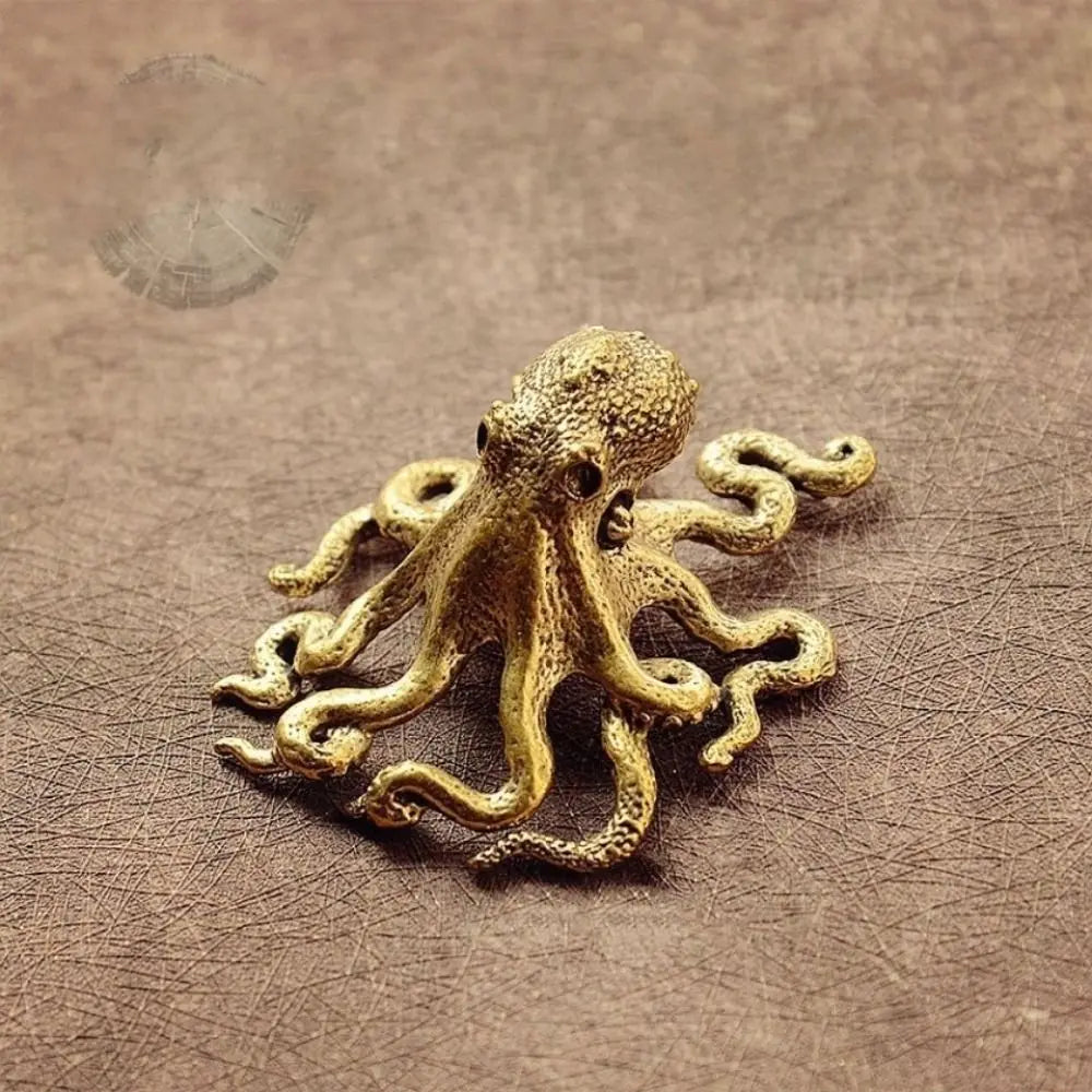 Antique brass octopus desk ornament resting on brown leather surface.