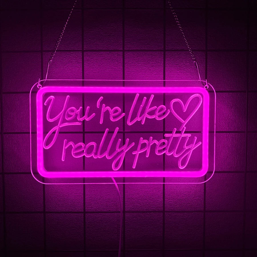 A neon sign in bright pink lights shaped like a rectangle with the text You're like really pretty.