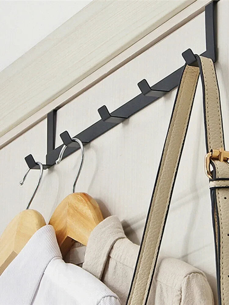A black door and wall organizer rack with five hooks is shown against a white background.