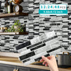 Self-adhesive marble wall tiles in various shades of gray and white being held by a hand against a dark subway tile backgroun