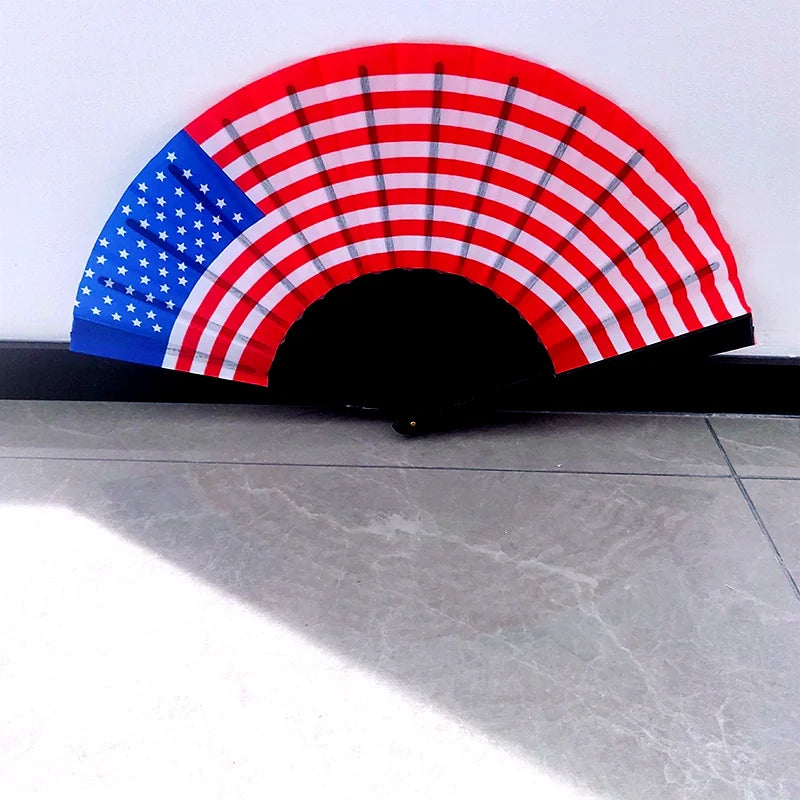 A handheld folding fan featuring the design of the American flag, displayed in a semi-circle.