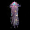 A translucent purple and pink jellyfish lantern hanging, featuring iridescent fibers and glowing accents.