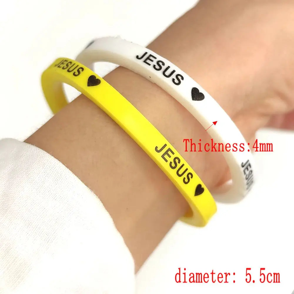 Yellow and white silicone bracelet with the word JESUS engraved on it, shown on a wrist.