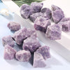 A collection of raw, purple amethyst crystal stones displayed on a white surface.