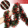 A hand is holding a thick, long red and green festive Christmas tinsel garland for holiday decor.