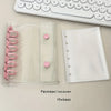A clear plastic binder cover and a white folder are shown next to a white keyboard.