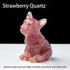 A pink strawberry quartz dog statue in a sitting position on a white surface.