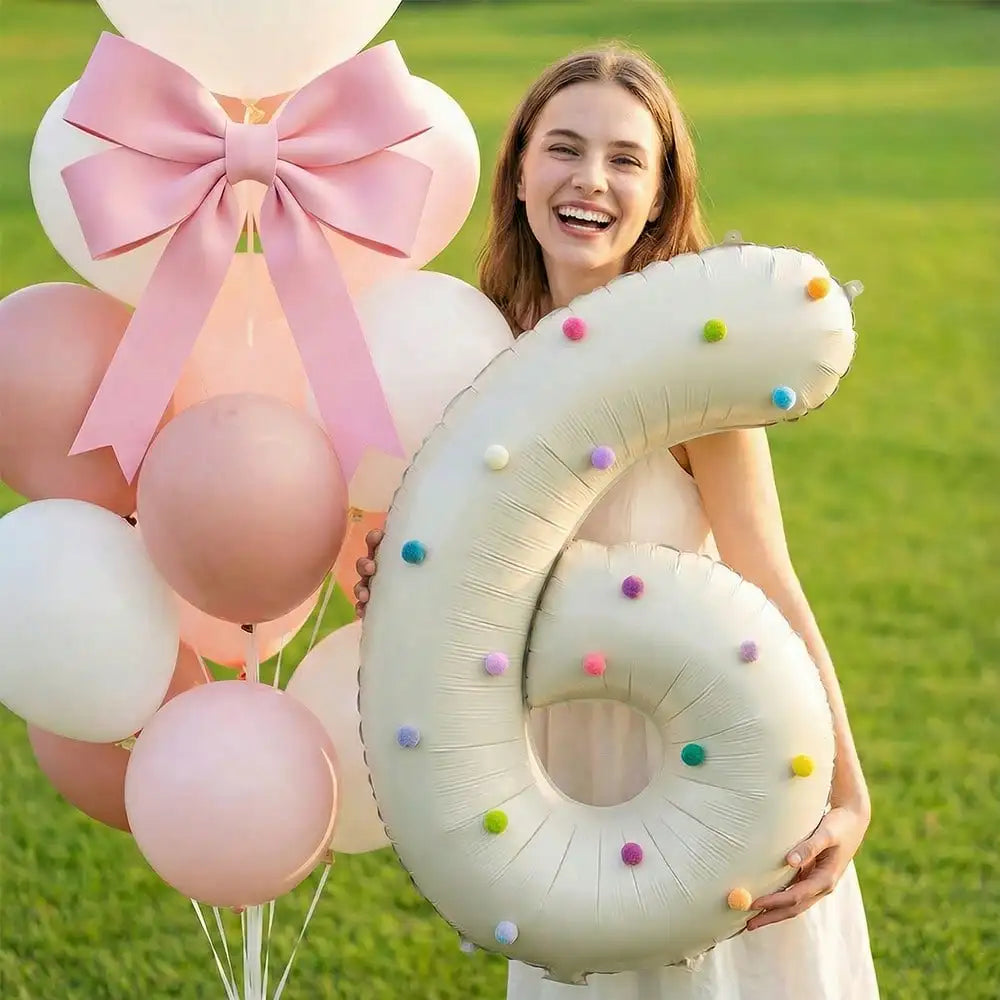 A young woman holds a large Milky White aluminum foil number balloon shaped like the number 6 in a grassy outdoor setting.