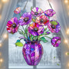 A colorful acrylic flower pot sun catcher ornament featuring purple and pink flowers hanging in a window.