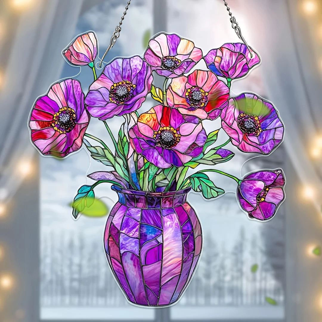 A colorful acrylic flower pot sun catcher ornament featuring purple and pink flowers hanging in a window.