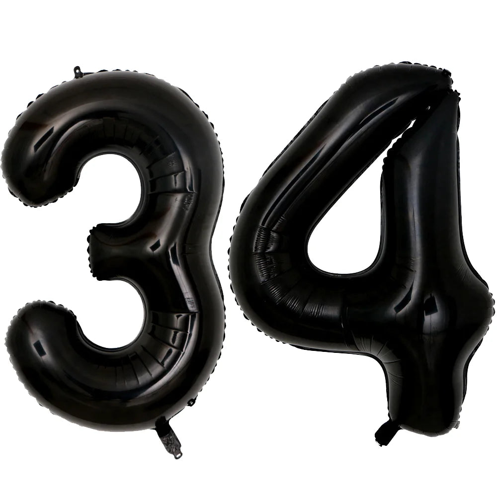 A set of two black foil balloons shaped like the number 3 and 4.