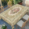 Vintage rose floral tablecloth spread over a wooden table with matching chairs in an outdoor setting