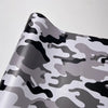 A close-up of a color-changing digital camouflage vinyl wrap film showing gray and black irregular patterns.