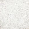 A close-up view of small, round, white frosted glass rice beads for jewelry making.