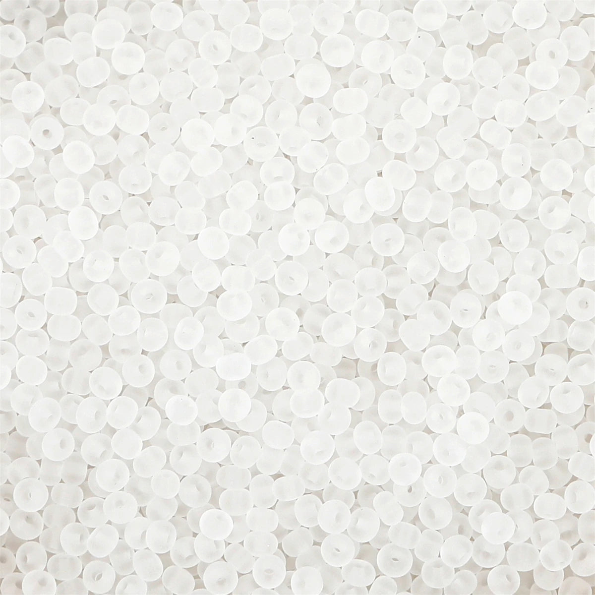 A close-up view of small, round, white frosted glass rice beads for jewelry making.