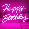 A bright pink neon sign spelling out Happy Birthday on a wall.