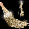 A close-up of golden lighted tinsel wedding wands with LED glow hanging from a string.