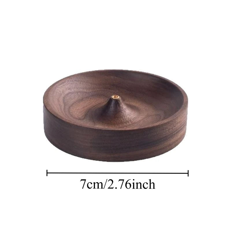 A round, dark brown solid wood incense stick burner with a small opening at the top.