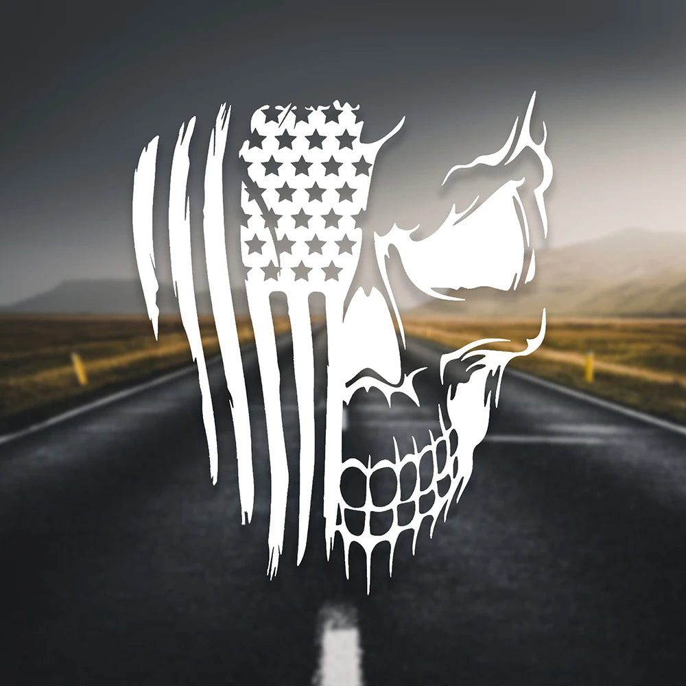 A white skull decal featuring the American flag design is placed on a dark asphalt road.