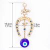 Gold amulet featuring an elephant charm and a blue eye pendant on a horseshoe shape.