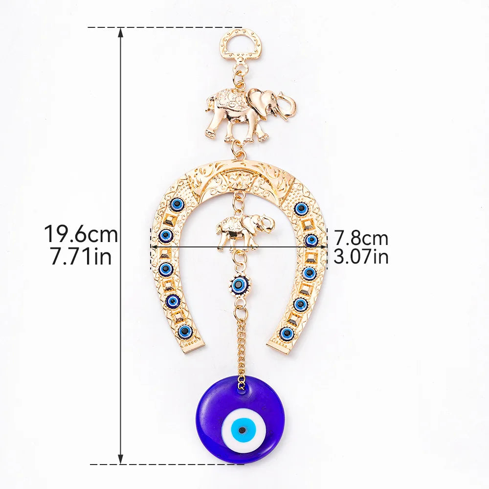 Gold amulet featuring an elephant charm and a blue eye pendant on a horseshoe shape.