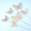 Pink and gold butterfly cake toppers on thin sticks for parties and baking