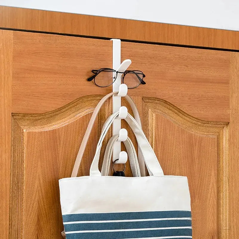 A white canvas tote bag with blue and white stripes is hanging on a white over-the-door hook.