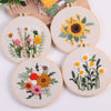 Punch needle embroidery kit featuring stamped cloth and tools with floral designs of sunflowers and daisies