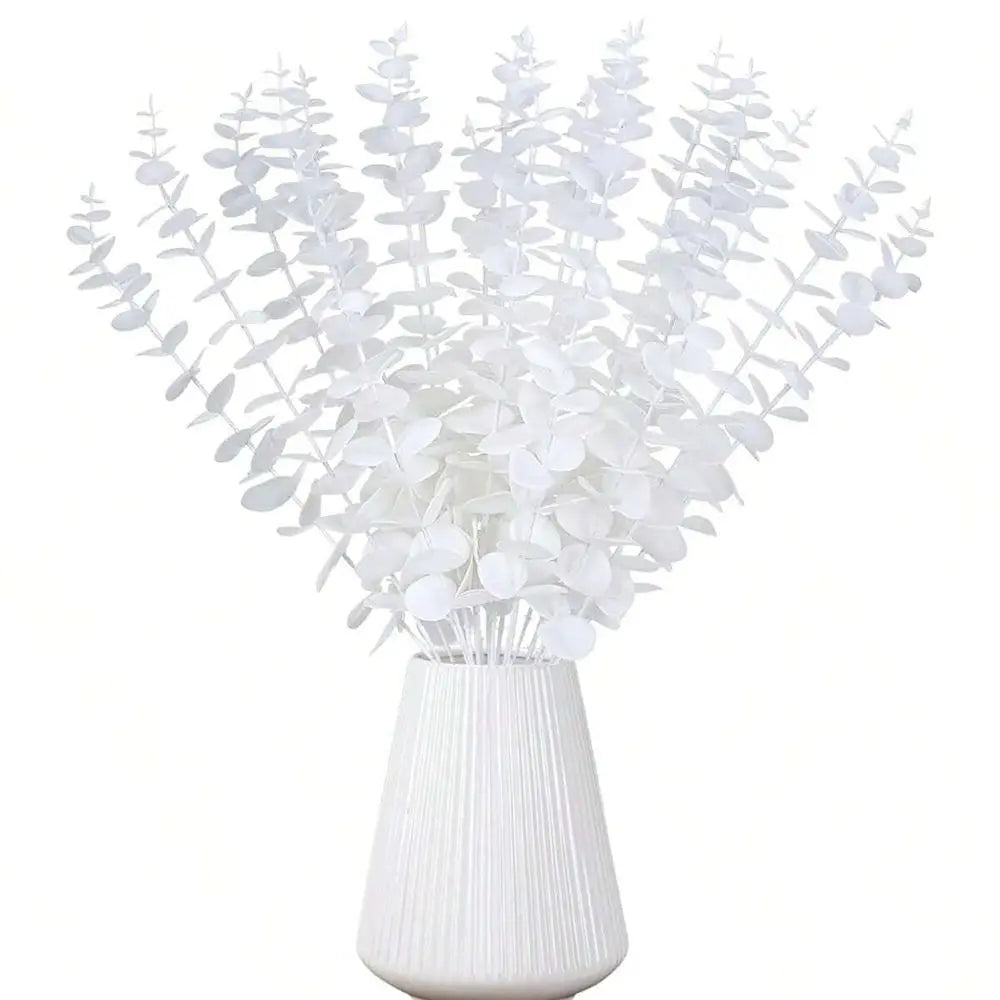 A bouquet of artificial white eucalyptus leaves displayed in a glass vase.
