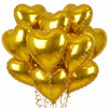 A bunch of gold heart-shaped foil balloons tied together for a celebration.